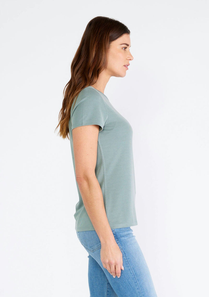 [Color: Slate Green] A side facing image of a brunette model wearing a classic seafoam green slim fit tee shirt with a crew neckline and short sleeves, crafted from a ribbed knit. 