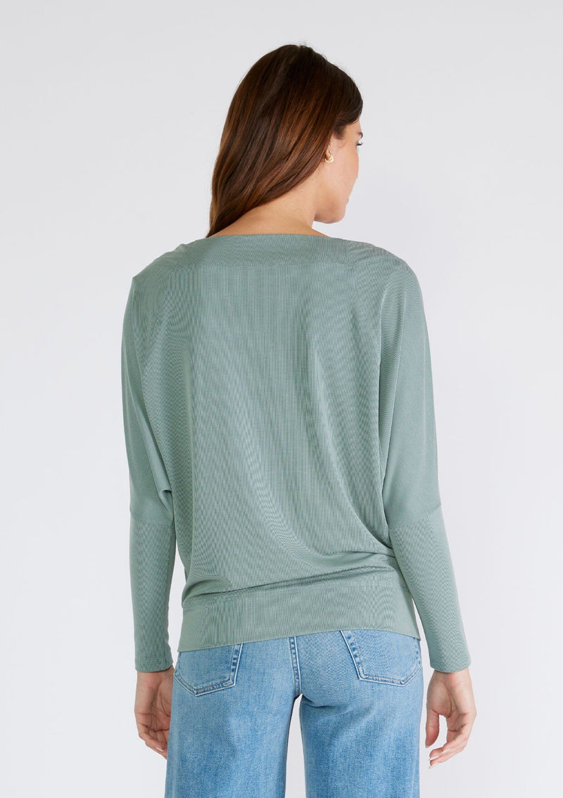 [Color: Slate Green] A back facing image of a brunette model wearing a seafoam green soft ribbed knit pullover. With long dolman sleeves and a wide boat neck that can be worn on or off the shoulder. 