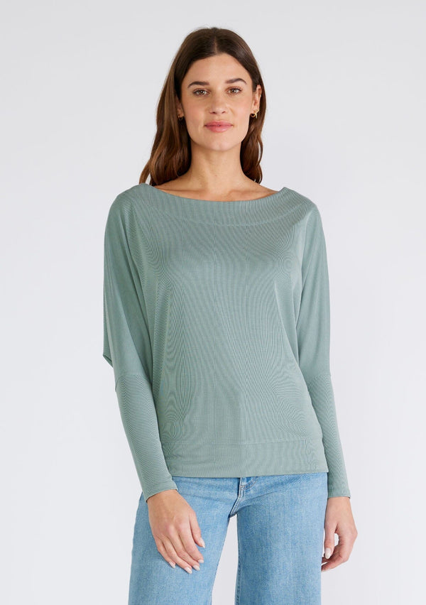 [Color: Slate Green] A front facing image of a brunette model wearing a seafoam green soft ribbed knit pullover. With long dolman sleeves and a wide boat neck that can be worn on or off the shoulder. 