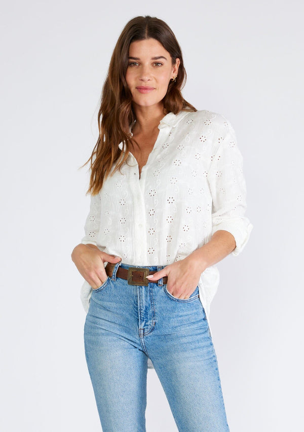 [Color: White] A front facing image of a brunette model wearing a classic white bohemian shirt crafted in embroidered eyelet cotton. With long sleeves, a classic collared neckline, and a button front. 