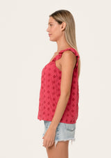 [Color: Fuchsia] A side facing image of a blonde model wearing a pink summer top with embroidered eyelet details. With a button front, flutter straps, and a scoop neckline.