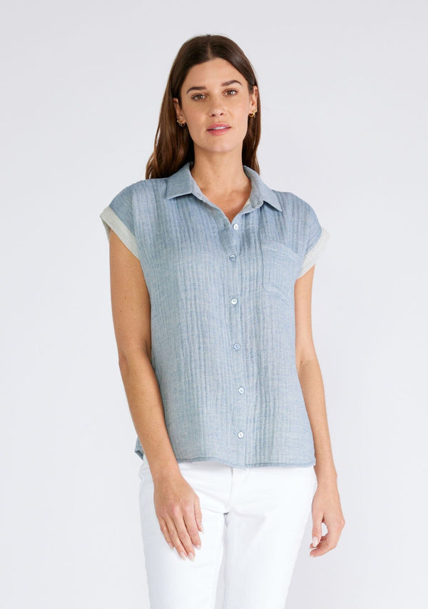 [Color: Dusty Blue] A front facing image of a brunette model wearing a light blue short sleeve shirt crafted from soft cotton gauze. With a button up front, a collared neckline, a front patch pocket, and short contrast cap sleeves. 