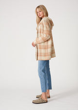 [Color: Taupe/Blue] A side facing image of a blonde model wearing a fuzzy hooded cardigan in a brown plaid design. With long sleeves and an open front. 