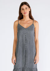 [Color: Ash Grey Wash] A close up front facing image of a brunette model wearing an ash grey wash sleeveless maxi dress made from Tencel. With adjustable spaghetti straps, a v neckline, and a long flowy tiered silhouette. 