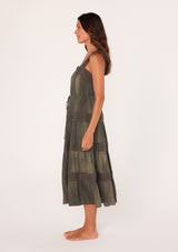 [Color: Olive] A side facing image of a brunette model wearing an olive green bohemian mid length dress. With a square neckline, a tiered flowy skirt, adjustable tank top straps, a button front top, a drawstring tie waist, and lace trim throughout.