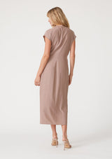 [Color: Mocha] A back facing image of a blonde model wearing a light brown maxi length wrap dress. With short cap sleeves, a deep v neckline, and a side tie waist closure. 