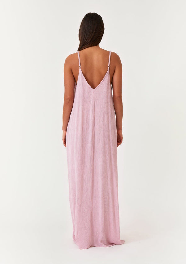 [Color: Orchid] A back facing image of a brunette model wearing an orchid purple sleeveless maxi dress with gold metallic thread details. With adjustable spaghetti straps, a deep v neckline in the front and back, side pockets, and a loose, oversized flowy fit. 