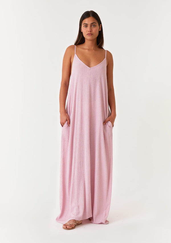 [Color: Orchid] A front facing image of a brunette model wearing an orchid purple sleeveless maxi dress with gold metallic thread details. With adjustable spaghetti straps, a deep v neckline in the front and back, side pockets, and a loose, oversized flowy fit. 