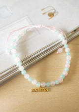 Bracelet with a mama charm with pink and green beads.