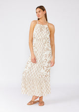 [Color: Latte/Natural] A front facing image of a brunette model wearing an dreamy bohemian maxi dress in an ivory and brown print. With spaghetti straps, a high neckline, a front keyhole detail, a tie neckline, an elastic waist, a tiered flowy skirt, and ladder stitch details throughout. 