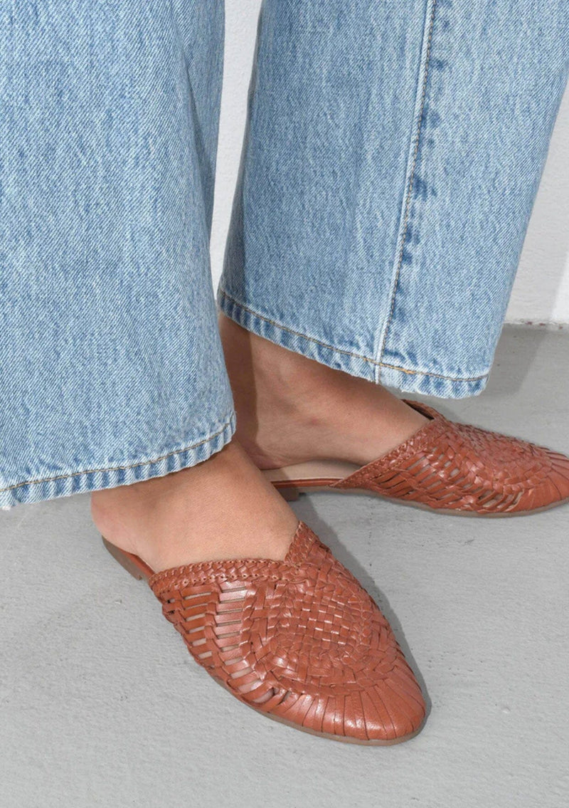 [Color: Cognac] Handwoven leather basketweave slip on mules in cognac brown. With a braided topline and flat rubber sole. Sustainably and ethically made in India. 