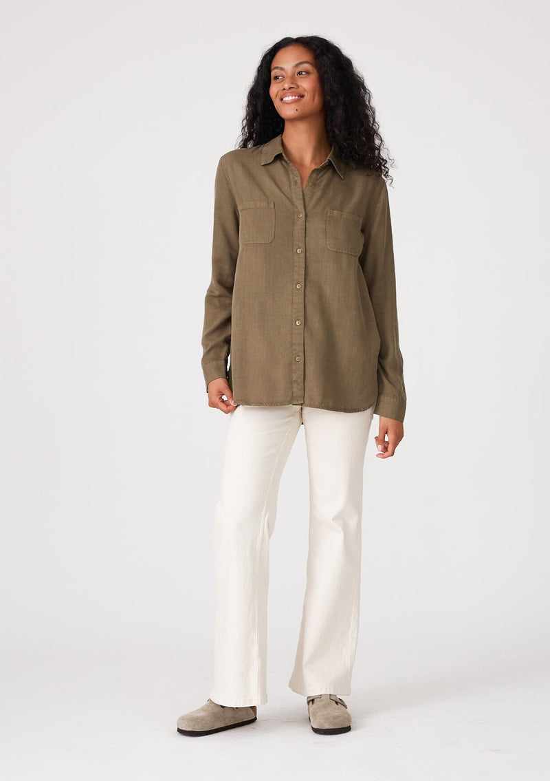 [Color: Military] A front facing image of a brunette model wearing a relaxed fit olive green shirt. With long sleeves, a collared neckline, a button front, and front patch pockets. 