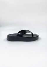 [Color: Black] A minimalist pair of black thong platform leather sandals. 