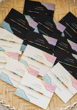 An adjustable healing bracelet, crafted on a durable nylon cord with gold-plated hardware and chakra colored natural gemstones. Designed by Kindred Row.