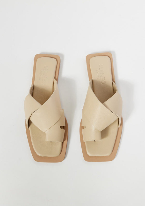 [Color: Creme] A simple and sophisticated ivory leather flat slip on sandal with a toe hold.