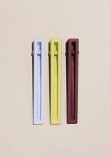 [Color: Desert Sky] A set of three long alligator style metal hair clips in lime green, light lavender, and brick brown. 