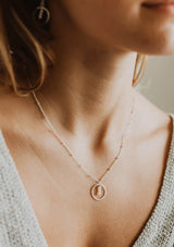 Sterling silver necklace with a circular pendant featuring three fresh water pearls suspended by a delicate beaded chain.