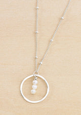 Sterling silver necklace with a circular pendant featuring three fresh water pearls suspended by a delicate beaded chain.