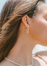 Delicate chain hoop earrings with freshwater pearls. Crafted from fourteen karat gold on sterling silver base, these beachy earrings are hypoallergenic and tarnish resistant.