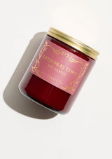 A fall and holiday candle in a burgundy glass jar labeled “P.F. Candle Co. Cathedral Clove.”