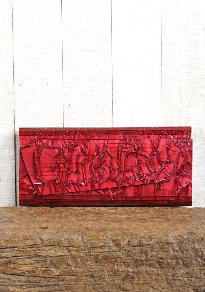 [Color: Lipstick] A pearlescent clutch made from molded resin. Features a magnetic closure.