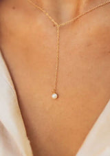 A dainty fourteen karat gold plated on sterling silver necklace with a drop accent and freshwater pearl. Hypoallergenic and made in the USA.