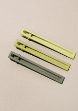 [Color: Spring] A set of three long alligator style metal hair clips in shades of green.