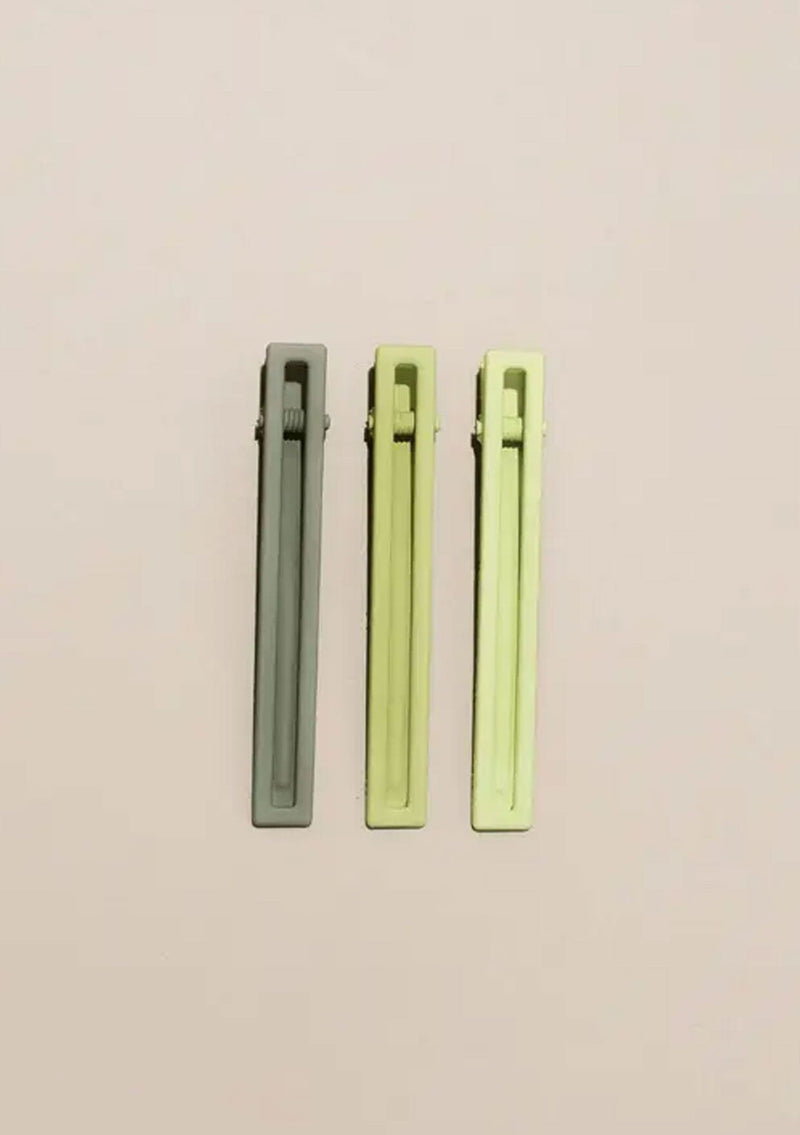[Color: Spring] A set of three long alligator style metal hair clips in shades of green.
