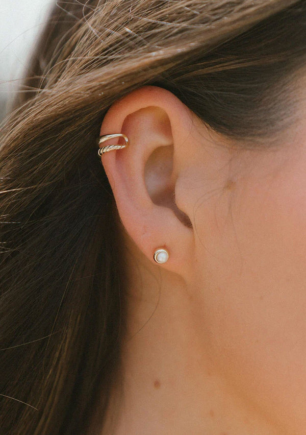 Simple and dainty pearl stud earrings. Crafted from fourteen karat gold plated sterling silver, these everyday stud earrings are hypoallergenic and tarnish resistant. 