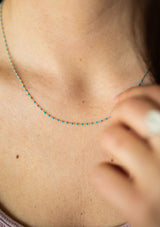 A fourteen karat gold plated on sterling silver necklace with turquoise enamel beads. Hypoallergenic and made in the USA. 