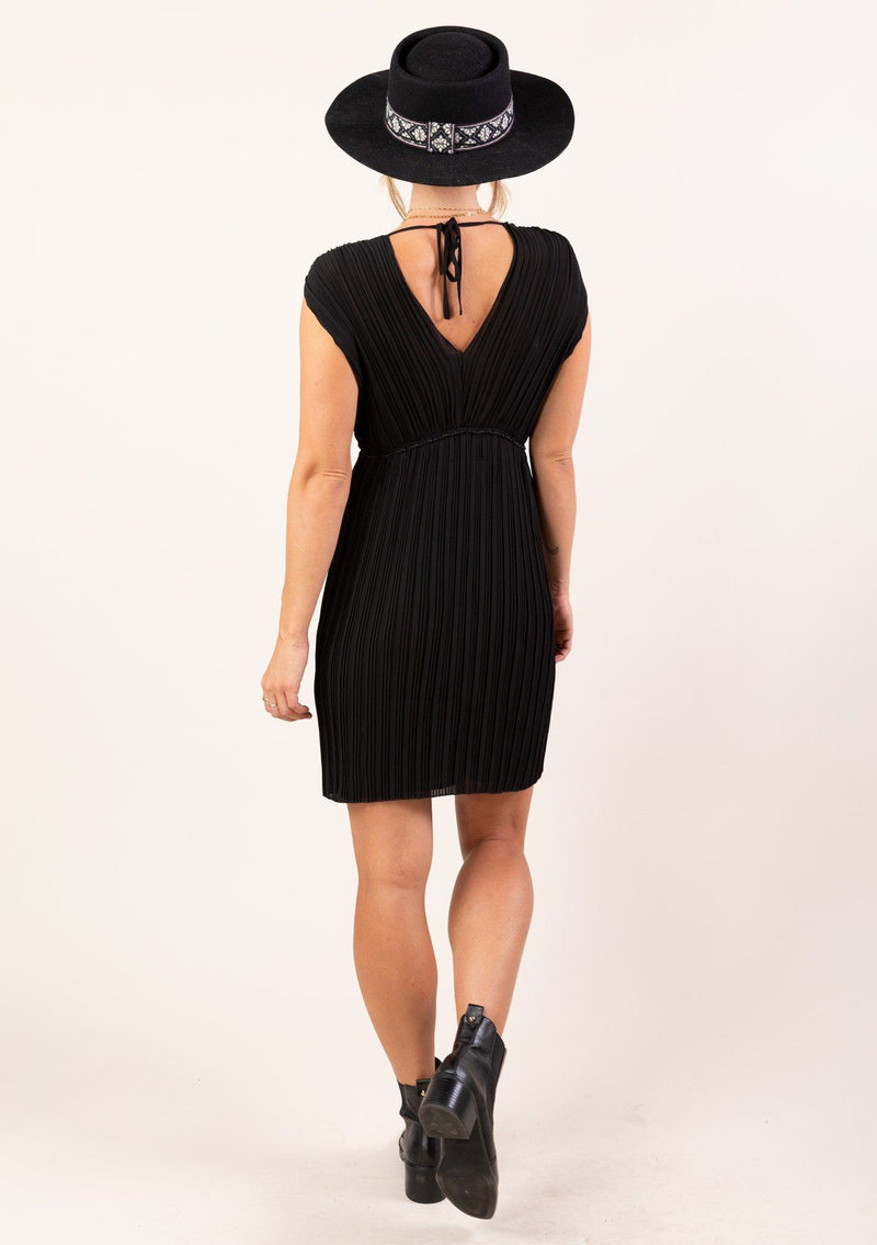[Color: Black] A sleeveless pleated chiffon mini length dress. Featuring a flirty open tie back detail, a flattering empire waist with ruffle detail, and elegant pleating throughout. 