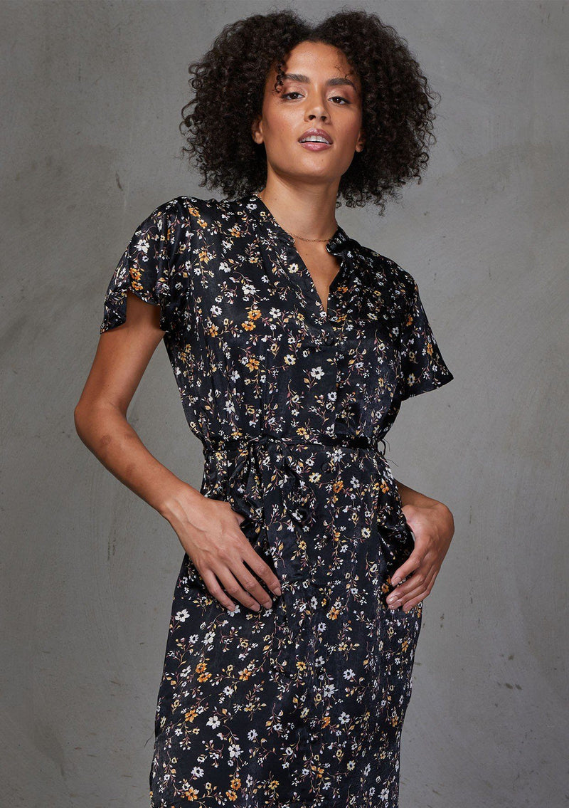 [Color: Black] Add some flower power to your wardrobe with our soft and silky floral print shirt dress. Featuring flirty flutter sleeves, delicate self covered buttons, and a flattering waist defining self tie belt. Styled here with sneakers. 