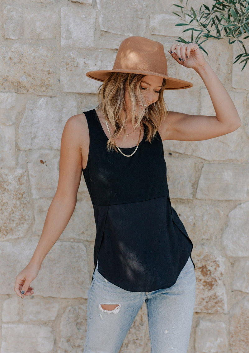 [Color: Black] Girl wearing a mixed media black sleeveless tank top with a scoop neckline.