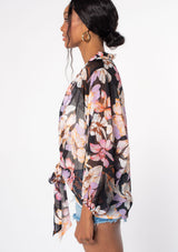 [Color: Black/Lilac] A model wearing a black sheer chiffon long sleeve tie front kimono top in a purple floral print. Perfect for spring and beach days as a cover up. 