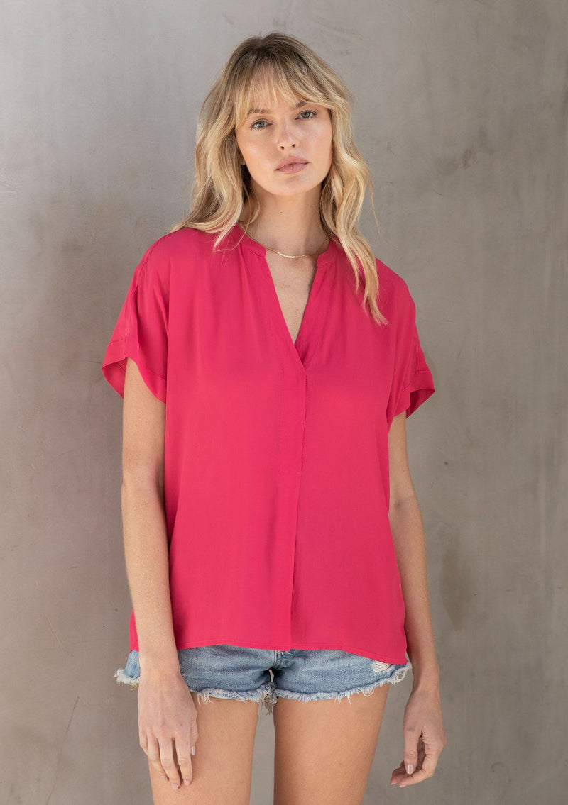 [Color: Watermelon] A model wearing a lightweight bright pink cuffed sleeve top in a soft, silky crepe. With an easy popover silhouette, perfect for work or play. 