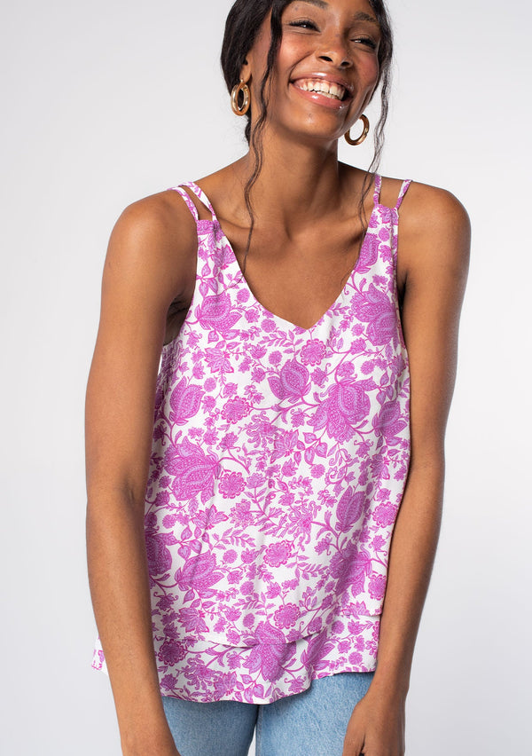 [Color: Ivory/Lilac] A model wearing a purple and white floral print tank top with strappy tie back detail and flowy fit. 