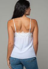 [Color: Chalk] A back facing image of a brunette model wearing a white lace trim camisole with a v neckline, adjustable spaghetti straps, and a flowy relaxed fit. 