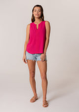 [Color: Fuchsia] A full body front facing image of a brunette model wearing a bohemian pink cotton tank top with a split v neckline, embroidered trim, and a relaxed fit.