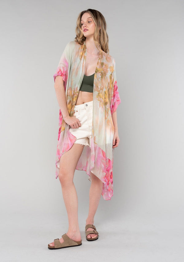 [Color: Mustard/Fuchsia] A full body front facing image of a blonde model wearing a lightweight bohemian mid length kimono in a mustard yellow and fuchsia pink watercolor floral print. With half length kimono sleeves, an open front, and side slits. 