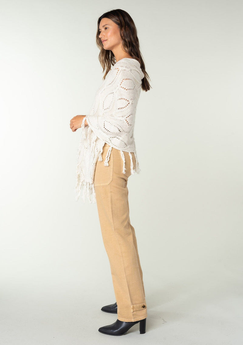 [Color: Heather Cream] A vintage inspired sweater poncho knit from a cream speckled yarn. With a fringed hemline. 