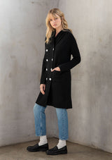 [Color: Black] A classic and essential hooded black coatigan. A cozy and effortlessly chic cardigan coat, featuring essential side pockets, a cozy oversized hood, and a contrast white shell button up front. 