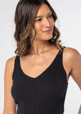 [Color: Black] A model wearing a black slim fit knit sweater tank top with adjustable straps and a v neckline.