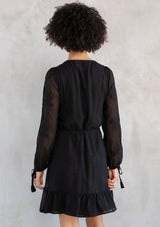 [Color: Black] A model wearing a charming black embroidered chiffon mini wrap dress, with sheer long split sleeves, lattice trim details, and a wrap front with side tie closure.