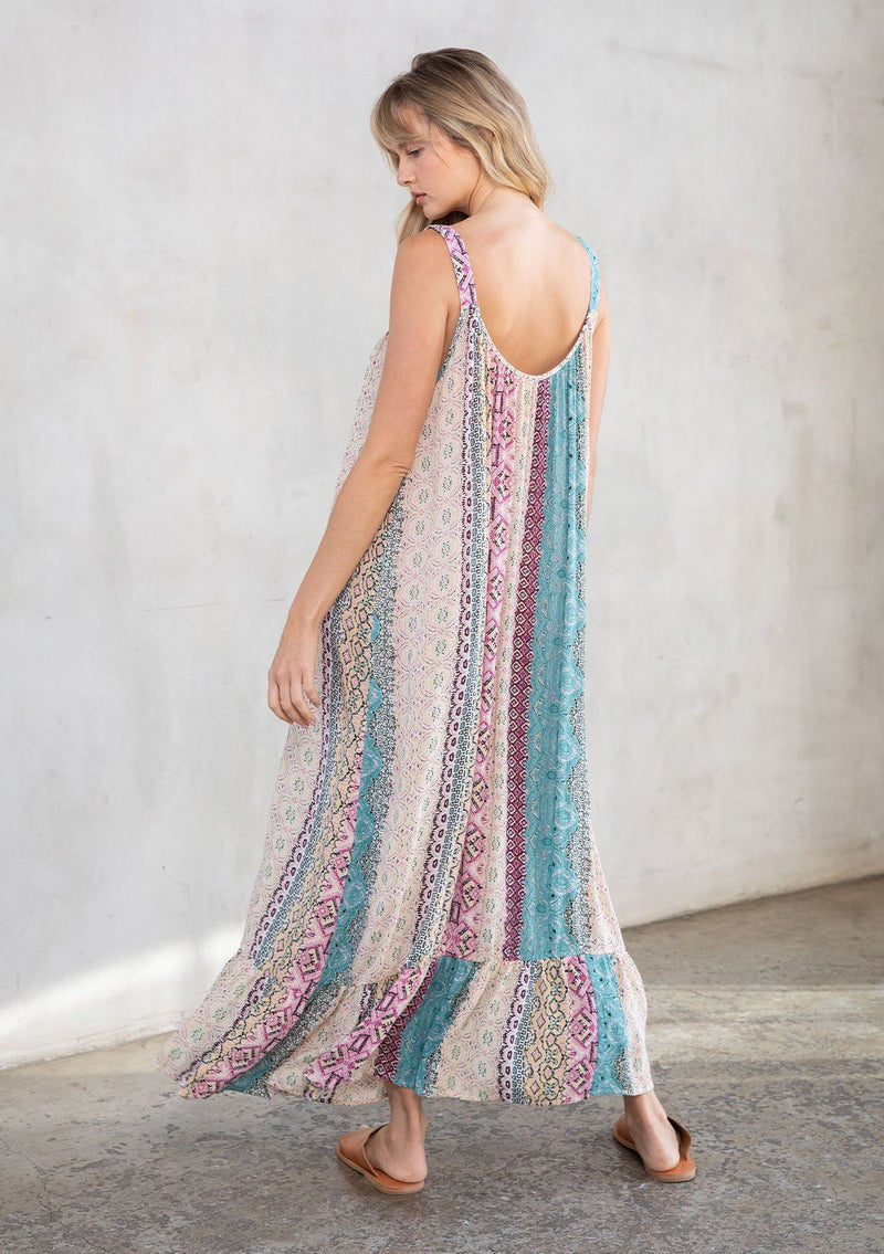 [Color: Mauve Multi] A model wearing a vacation ready sleeveless maxi dress in a multicolor mixed print. With a ruffled round neckline, a relaxed flowy fit, and metallic thread details.