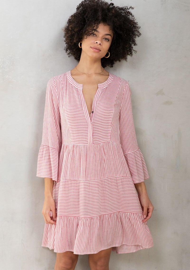 [Color: Red/Ivory] A model wearing a classic relaxed yarn dye mini shirt dress in a red and ivory stripe. With three quarter length bell sleeves, a tiered skirt, and a loose, relaxed silhouette. 