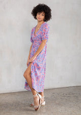 [Color: Ivory/Cobalt] A model wearing a vintage inspired bohemian puff sleeve midi dress in a red, ivory and blue paisley. With ruffled trim, a drawstring empire waist, and a back keyhole. 