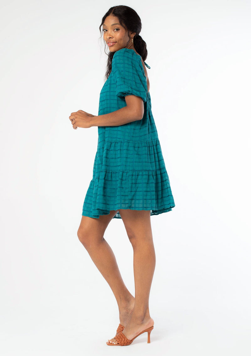[Color: Teal] A model wearing a bohemian white cotton mini dress with short puff sleeves and a relaxed flowy fit.