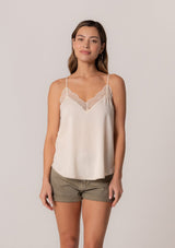 [Color: Vanilla] A front facing image of a brunette model wearing an ivory camisole tank top. With spaghetti straps, a v neckline, lace trim, a racerback, and a relaxed fit.