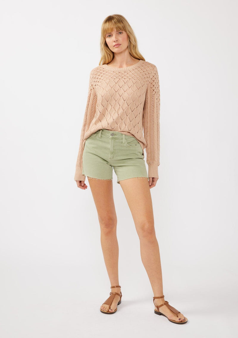 [Color: Truffle] A front facing image of a blonde model in an orange-tan pointelle cable knit sweater with long sleeves, a round neckline, and ribbed trim—a lightweight, breezy layer ideal for casual days, resort looks, or cozy beach mornings.