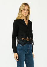 [Color: Black] A side facing image of a blonde model wearing a black lace cardigan with a button front. 